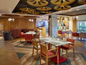 een restaurant met tafels en stoelen in een kamer bij Hotel Swosti Premium Bhubaneswar in Bhubaneshwar