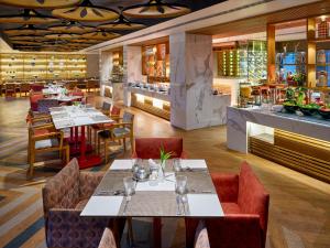 een restaurant met tafels en stoelen en een bar bij Hotel Swosti Premium Bhubaneswar in Bhubaneshwar