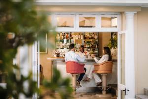 ein Mann und eine Frau sitzen an einer Bar in der Unterkunft Birkenhead House in Hermanus