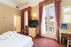 een hotelkamer met een bed, een tv en een raam bij Hotel Terme Roma in Abano Terme