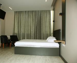 a bedroom with a bed and a window with chairs at zoom hotels in Eskiömerler