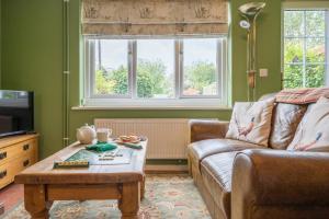 a living room with a couch and a coffee table at 1 Lavender Cottages, Knodishall in Saxmundham