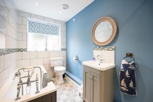 a bathroom with a tub and a sink and a toilet at 1 Lavender Cottages, Knodishall in Saxmundham +26 photos