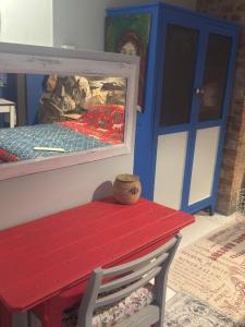 a red bench sitting next to a blue door at Memento Vivere in Mossel Bay