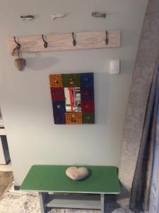 a green bench next to a wall with a mirror at Memento Vivere in Mossel Bay +25 photos