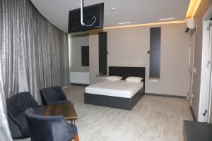 a bedroom with a bed and two chairs and a table at Zoom Airport Hotels in Istanbul