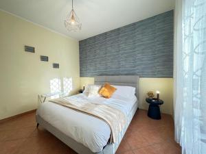 a bedroom with a large bed with white sheets and orange pillows at Casa Letizia in Ladispoli