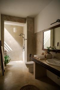 a bathroom with a sink and a toilet and a mirror at Mimosa Hill in Hiriketiya +22 photos