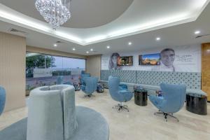 a waiting room with blue chairs and a chandelier at Hotel Cartagena Plaza in Cartagena de Indias