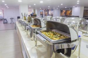 a buffet line with trays of food on them at Hotel Cartagena Plaza in Cartagena de Indias