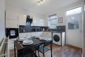 a kitchen with a table and chairs and a kitchen with a dishwasher at Stylish 3BR House - Sleeps 5 - Free Parking in Ferryhill