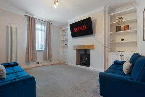 a living room with two blue couches and a tv at Stylish 3BR House - Sleeps 5 - Free Parking in Ferryhill