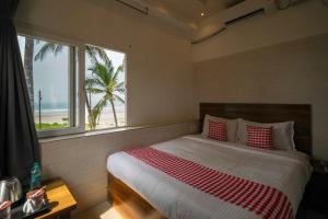 a bedroom with a bed with a view of the beach at Open Hotel by Olive - Amani Beach Stay in Māvalli