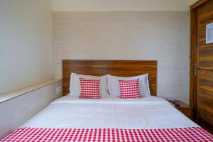 a bedroom with a bed with red and white pillows at Open Hotel by Olive - Amani Beach Stay in Māvalli