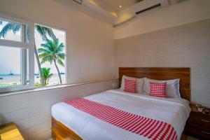 a bedroom with a bed with a view of the beach at Open Hotel by Olive - Amani Beach Stay in Māvalli