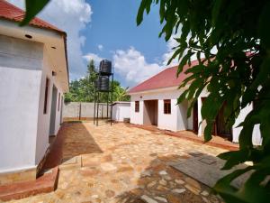 a courtyard with two buildings and a water tower at Nile River Inn in Buloba