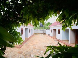 a courtyard of two white buildings with a basketball hoop at Nile River Inn in Buloba