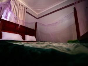a bedroom with a bed with a red head board at Nile River Inn in Buloba