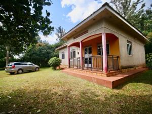 a small house with a car parked in front of it at Nile River Inn in Buloba