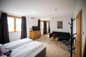 a bedroom with a bed and a couch at Strommer wine das Gästehaus in Purbach am Neusiedlersee