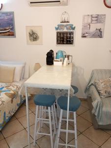 a kitchen with a table and two blue bar stools at Il Posto Nascosto in Porto Torres