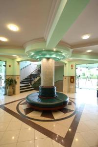 a lobby with a fountain in the middle of a building at Hotel APAN in Reggio di Calabria