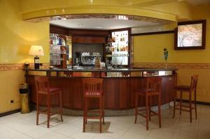 a bar in a restaurant with red stools at Hotel APAN in Reggio di Calabria