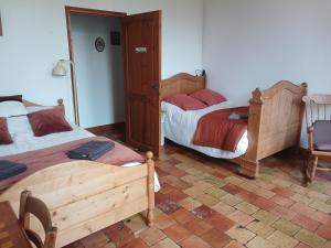 a bedroom with two beds and a table and chairs at Gîte de la glycine in Marmande