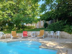 a group of chairs sitting next to a pool at Gîte de la glycine in Marmande
