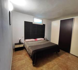 ein Schlafzimmer mit einem Bett mit schwarzem Kopfteil und rosa Kissen in der Unterkunft Villa Circuito Simoncelli in Misano Adriatico