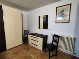 ein Zimmer mit einer Kommode, einem Stuhl und einem Spiegel in der Unterkunft Villa Circuito Simoncelli in Misano Adriatico