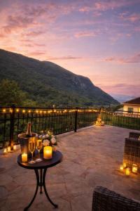 a patio with a table with wine glasses and lights at Vila na Rtnju in Rtanj