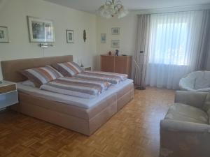 een slaapkamer met een groot bed en een bank bij Ferienwohnung Schabmüller in Kelheim