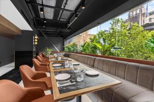 a dining room with a table and chairs at Radisson RED Auckland in Auckland