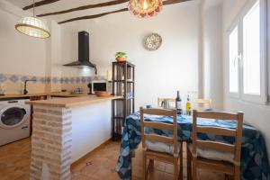 a kitchen and dining room with a table and chairs at The Tile House in Güéjar-Sierra