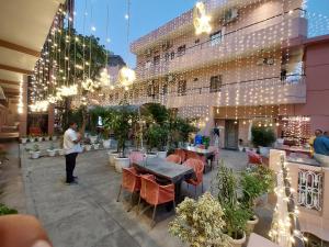 a man standing in front of a building with lights at Hotel Alka in Varanasi