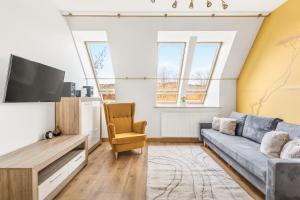 a living room with a couch and a tv at Apartamenty Oaza Superior Zakopane in Zakopane