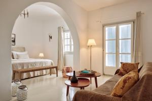 een woonkamer met een bank en een bed bij Hotel Adonis in Mykonos-stad