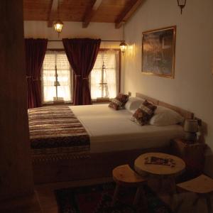 a bedroom with a large bed and two windows at Hotel Ari Old Town in Gjakove +16 photos