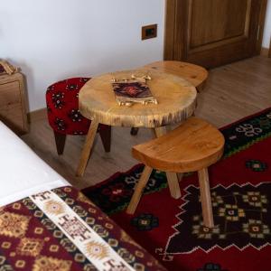 a wooden table and two stools in a room at Hotel Ari Old Town in Gjakove