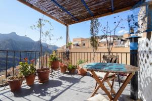 a balcony with a table and potted plants at The Tile House in Güéjar-Sierra