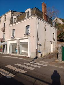een oud wit gebouw aan de straatkant bij T2 lumineux - Segré hyper Centre - Wifi - Netflix in Segré