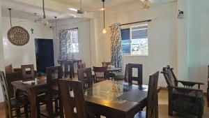 a dining room with a wooden table and chairs at Three Elements Mirissa in Mirissa