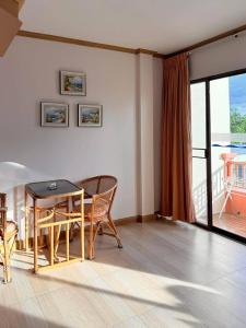 een woonkamer met een tafel en stoelen en een balkon bij Takiab Beach Resort in Hua Hin