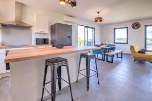 una cucina e un soggiorno con bancone e sgabelli di Sunset villa a Trélissac Altre 42 foto