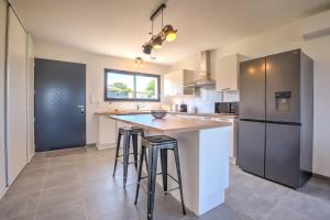 una cucina con una grande isola con sgabelli da bar di Sunset villa a Trélissac
