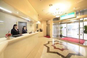 two women standing at a counter in a lobby at UrbanHotelTokyoShinmatsudo in Matsudo