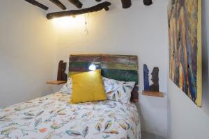 a bedroom with a bed with a yellow pillow at The Tile House in Güéjar-Sierra