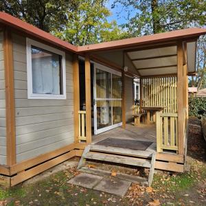 a small house with a porch and a bench on it at Chalet KABANA in Saint-Hilaire-de-Riez