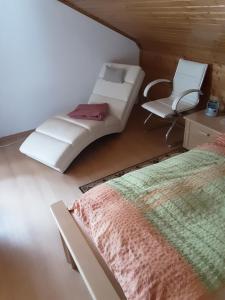 ein Schlafzimmer mit einem Bett und einem Stuhl in der Unterkunft FW Doris in Ruhla + 8 Fotos